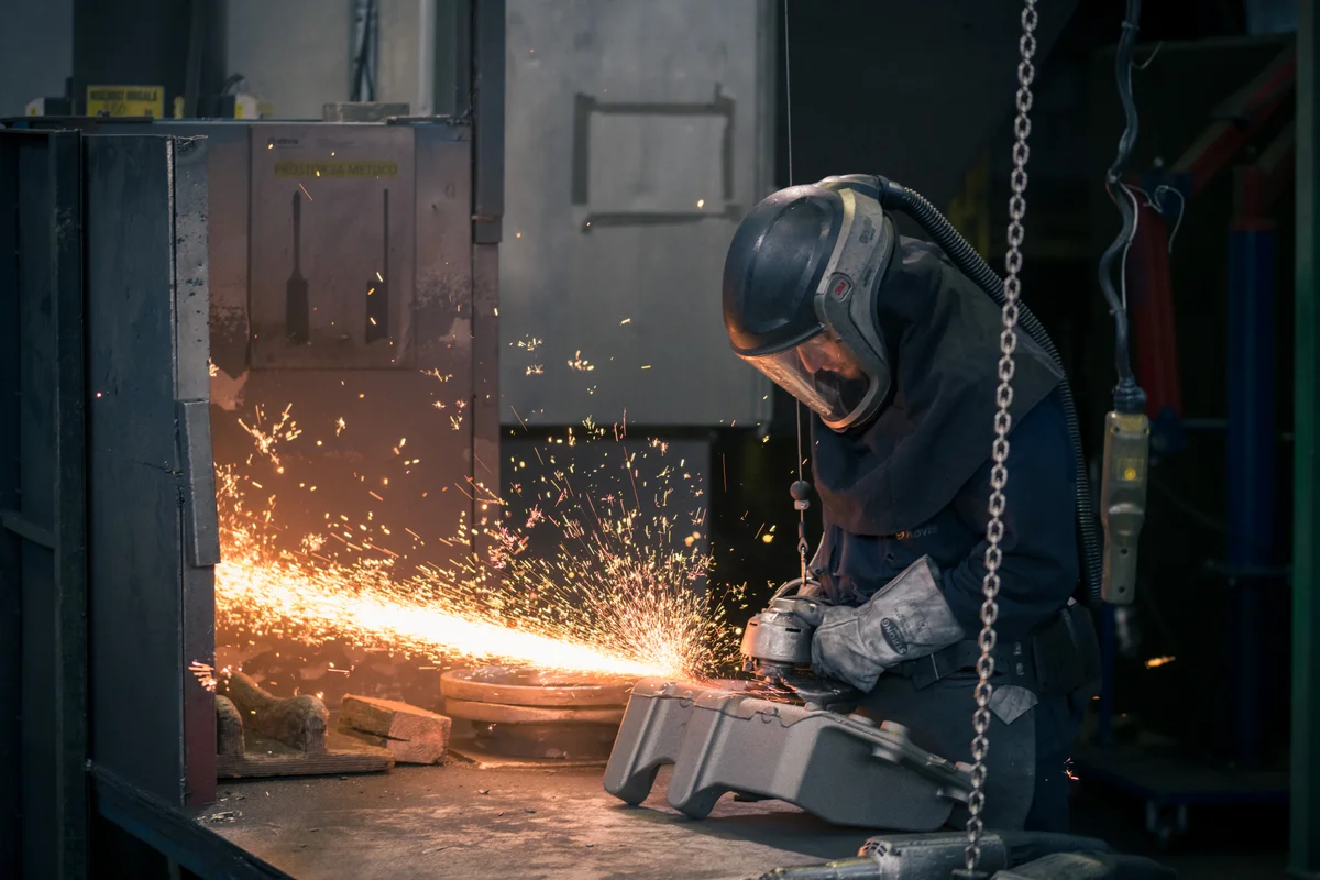 Worker finishing a casting with sparks
